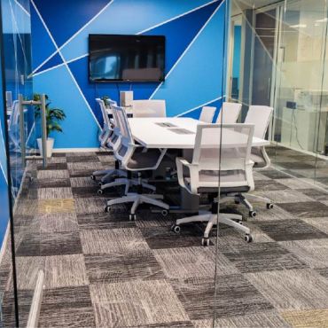 Professional and comfortable conference room for up to 8 people, ideal for meetings, interviews, presentations, and small team sessions. Features a conference table, comfortable seating, TV, and dry-erase board.