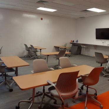 Coworking Space with a capacity to seat 30 people with tables and 50 people without tables. This room also has a full white-board wall and smart TV